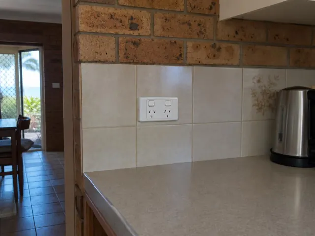 White double power point on tiled kitchen splashback above a bench in a home interior in Mermaid Beach