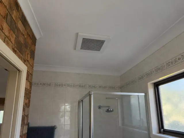 Ceiling exhaust fan in a tiled bathroom with shower and window in Burleigh Heads
