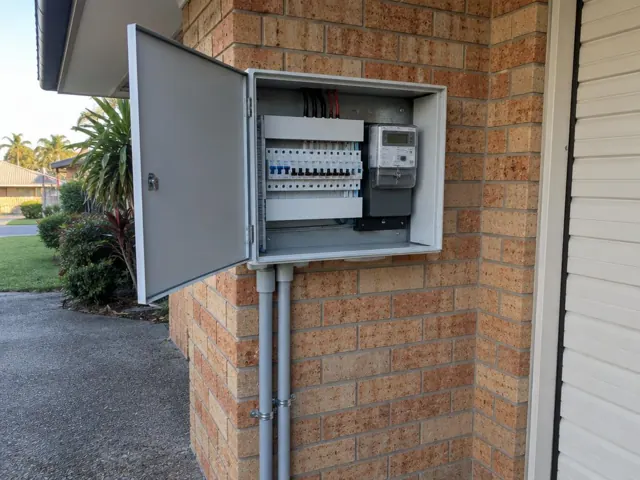 Open external switchboard on a brick house wall beside the entry in Burleigh Waters